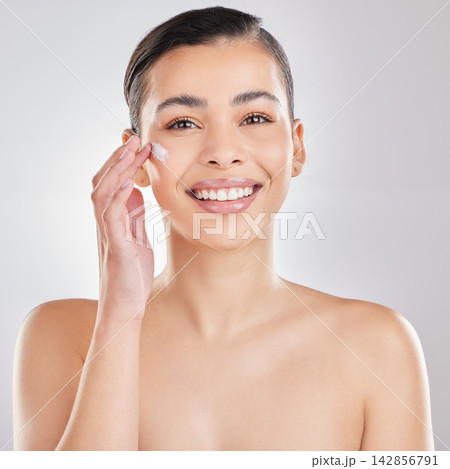 Portrait, cream and woman with aesthetic, smile and dermatology on a white studio background. Face, person and model with lotion, shine or creme with skincare, moisturizer and wellness with cosmetics Portrait, cream and woman with aesthetic, smile and dermatology on a white studio background. Face, person and model with lotion, shine or creme with skincare, moisturizer and wellness with cosmetics 142856791
