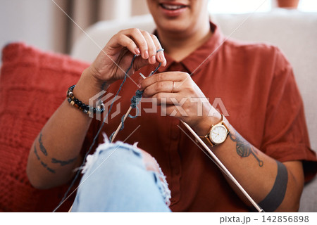 Hands, woman and knitting in living room for relax, hobby and creativity in home for fashion. Designer, female person and sewing or crochet on sofa in apartment with yarn, pride and cotton for craft 142856898
