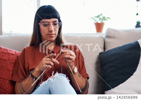 Creative, knitting and woman with wool in home for stitching project on sofa with needles. Craft, needlework and girl relax with yarn textile in apartment for calm activity or hobby on weekend 142856899