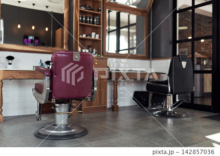 Barber, shop and chair with mirror in business for hair care, grooming and beauty. Professional, salon and furniture in room with cosmetics tools and equipment on shelf for hairdresser in store Barber, shop and chair with mirror in business for hair care, grooming and beauty. Professional, salon and furniture in room with cosmetics tools and equipment on shelf for hairdresser in store 142857036