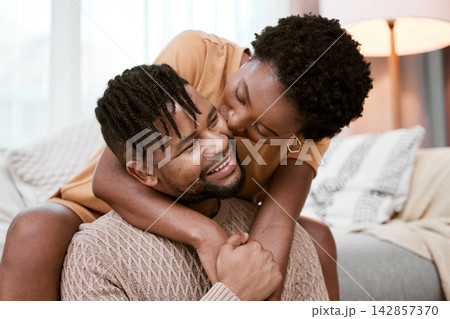 Couple, black woman and man in living room, kiss and hug for love, smile and romance in home to relax. House, African person and partner in lounge, embrace and happy for marriage and commitment Couple, black woman and man in living room, kiss and hug for love, smile and romance in home to relax. House, African person and partner in lounge, embrace and happy for marriage and commitment 142857370