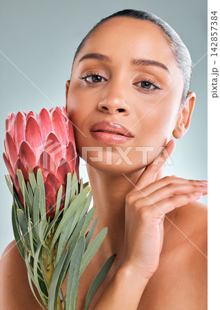 Portrait, woman and skincare with flower in studio on white background for organic or natural treatment. Female person, confident and protea plant for skin glow, smooth and wellness or sustainability Portrait, woman and skincare with flower in studio on white background for organic or natural treatment. Female person, confident and protea plant for skin glow, smooth and wellness or sustainability 142857384