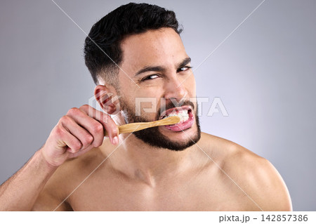 Portrait, man and toothbrush in studio background for oral hygiene, cleaning mouth and medical wellness. Male person, fresh and bamboo isolated for dental care, grooming and cavity prevention Portrait, man and toothbrush in studio background for oral hygiene, cleaning mouth and medical wellness. Male person, fresh and bamboo isolated for dental care, grooming and cavity prevention 142857386