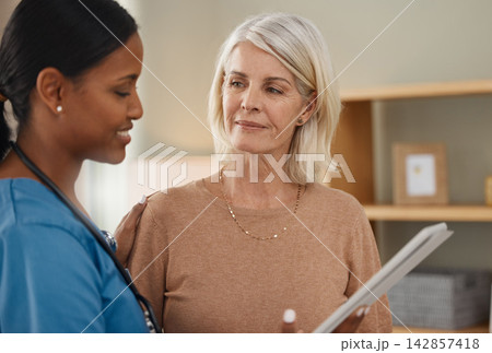 Mature woman, nurse and tablet in clinic or hospital for healthcare or wellness with patient records. People, medic and tech for support, medicine or results as professional for cardiovascular exam 142857418