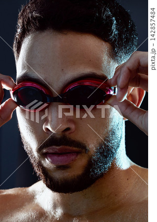 Goggles, swimmer or portrait of man ready for race, exercise or training on dark background in studio. Start, champion or proud athlete in swimming workout for fitness practice, development or sports 142857484