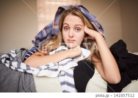 Woman, portrait and laundry pile for home chores or unhappy for cleaning fabric, washing or bored. Female person, face and housewife working for clothes hygiene or annoyed with linen, bed or cleaner 142857512