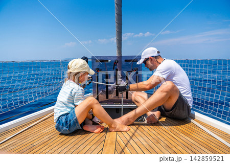 Father and daughter learning yacht maintenance together during a family sailing adventure. Building practical sailing skills, teamwork, confidence and responsibility through shared experience. Father and daughter learning yacht maintenance together during a family sailing adventure. Building practical sailing skills, teamwork, confidence and responsibility through shared experience. 142859521