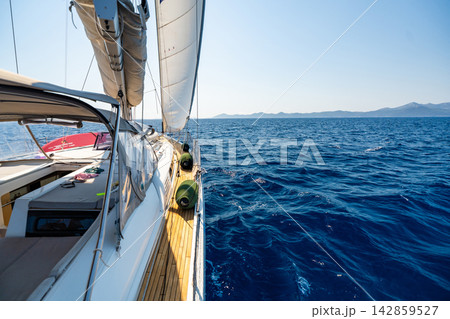 Sailing yacht cruising across the Adriatic Sea under full sail. Freedom and adventure during a long distance sailing voyage. Sailing yacht cruising across the Adriatic Sea under full sail. Freedom and adventure during a long distance sailing voyage. 142859527
