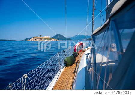 Historic Mamula Fortress on Lastavica Island in Montenegro viewed from a sailing yacht on the Adriatic Sea. Sailing adventure and maritime travel near the entrance to the Bay of Kotor. Historic Mamula Fortress on Lastavica Island in Montenegro viewed from a sailing yacht on the Adriatic Sea. Sailing adventure and maritime travel near the entrance to the Bay of Kotor. 142860035