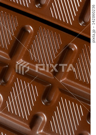 Chocolate bar with geometric line pattern, texture macro background Chocolate bar with geometric line pattern, texture macro background 142860236