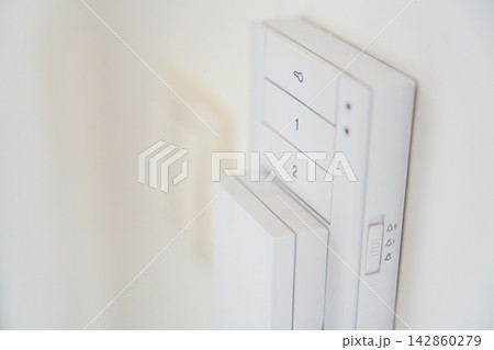 Close up of a home intercom control panel on a wall near an apartment entrance. Residential access control concept for security, communication and visitor management. Close up of a home intercom control panel on a wall near an apartment entrance. Residential access control concept for security, communication and visitor management. 142860279