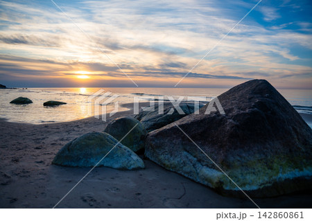 Rocky beach coastline on Ruegen island in Germany during sunset over the Baltic Sea. Travel, nature and seaside landscape with calm evening atmosphere Rocky beach coastline on Ruegen island in Germany during sunset over the Baltic Sea. Travel, nature and seaside landscape with calm evening atmosphere 142860861