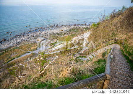Wooden staircase leading to Baltic Sea beach near Cape Arkona on Rugen island in Germany. Coastal hiking and nature exploration atmosphere. 142861042