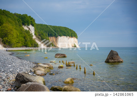 Famous white chalk cliffs and rocky Baltic Sea coastline in Jasmund National Park on Rugen island, Germany. Iconic natural landmark and coastal travel destination concept. Famous white chalk cliffs and rocky Baltic Sea coastline in Jasmund National Park on Rugen island, Germany. Iconic natural landmark and coastal travel destination concept. 142861065