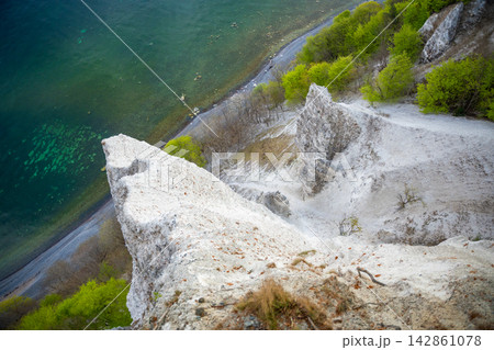 View of famous white chalk cliffs in Jasmund National Park on Rugen island, Germany. Scenic Baltic Sea coastline from forest trail View of famous white chalk cliffs in Jasmund National Park on Rugen island, Germany. Scenic Baltic Sea coastline from forest trail 142861078