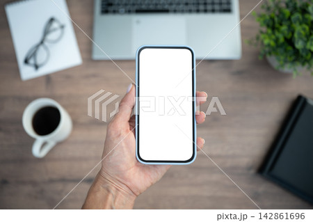Hand holding smartphone with blank white screen Hand holding smartphone with blank white screen 142861696