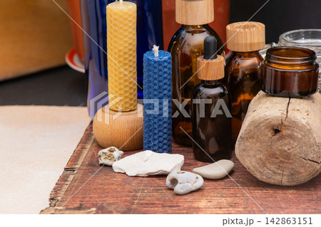 Beeswax Candle and Essential Oil Bottle. Aromatherapy Still Life with Candles and Bottles Beeswax Candle and Essential Oil Bottle. Aromatherapy Still Life with Candles and Bottles 142863151