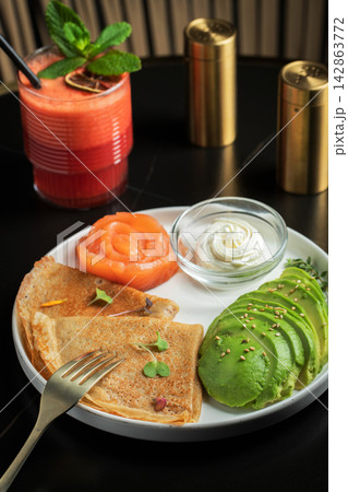 Roasted thin pancakes with smoked salmon and sauce Roasted thin pancakes with smoked salmon and sauce 142863772