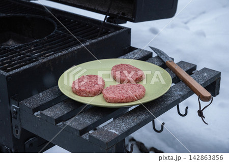 Raw burger patties on grill in winter Raw burger patties on grill in winter 142863856