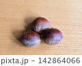 木のテーブルの上に並んだ栗 142864066