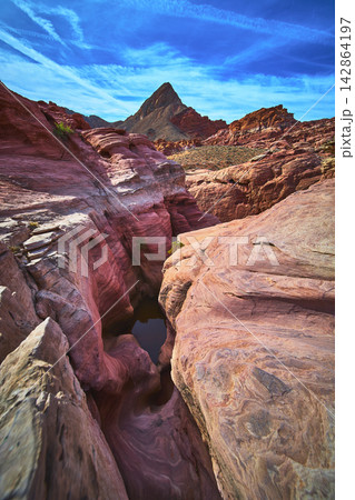 Slot Canyon Water Basin and Red Rock Formations Under Bright Blue Sky 142864197