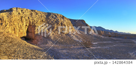 Panorama of Sunlit Fossil Bed Cliffs and Desert Plain at Golden Hour Panorama of Sunlit Fossil Bed Cliffs and Desert Plain at Golden Hour 142864384