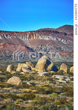 Desert Boulders and Rugged Cliffs under Blue Sky in Mojave California Desert Boulders and Rugged Cliffs under Blue Sky in Mojave California 142864770
