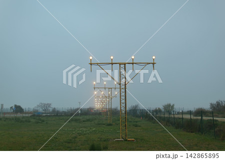 Runway approach lights in foggy landscape 142865895