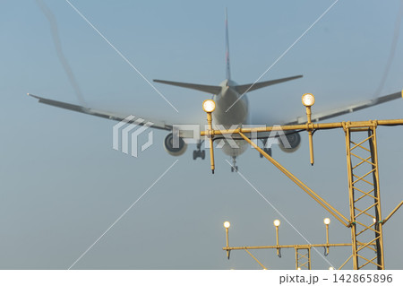Airplane landing approaching runway lights 142865896