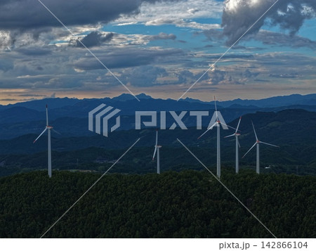 大分県玖珠町の山間部に立つ風力発電機を捉えた夕暮れの空撮写真 142866104