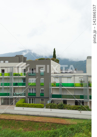 Modern apartment building with mountain backdrop Modern apartment building with mountain backdrop 142866337