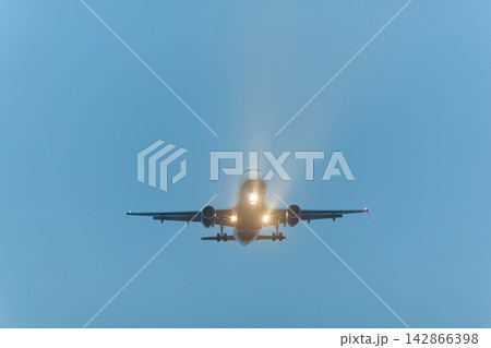 Airplane approaching with landing lights Airplane approaching with landing lights 142866398