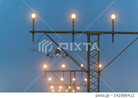 Landing airplane with runway lights Landing airplane with runway lights 142866412