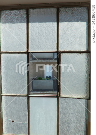 Old textured window with balcony view Old textured window with balcony view 142866419