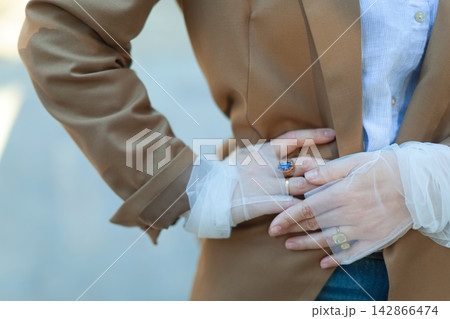 Close up of person in brown blazer with jewelry Close up of person in brown blazer with jewelry 142866474