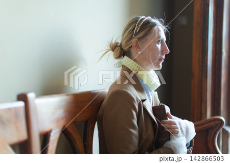 Woman in costume holding book Woman in costume holding book 142866503