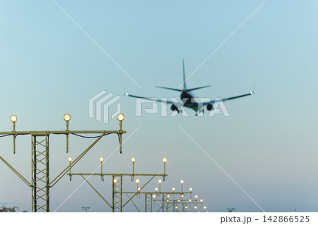 Airplane landing with runway lights Airplane landing with runway lights 142866525