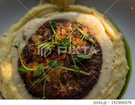 Pan fried cutlet close high angle with pea shoot cream sauce Pan fried cutlet close high angle with pea shoot cream sauce 142866876