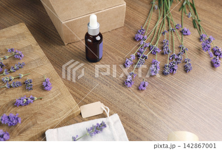 Lavender oil bottle and sachet pouch with flowers on wooden board. Flat lay composition for social media content creator and blogging backdrop. Elegant minimalist aesthetic decoration with copy space Lavender oil bottle and sachet pouch with flowers on wooden board. Flat lay composition for social media content creator and blogging backdrop. Elegant minimalist aesthetic decoration with copy space 142867001