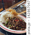 Authentic Thai stir-fried minced pork with holy basil and chili (Pad Kra Pao) served with steam rice and a crispy fried egg at a Thai restaurant in Hong Kong 142867047