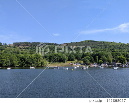 イギリス湖水地方・ウィンダミア湖の湖畔に浮かぶヨットと森林風景 142868027