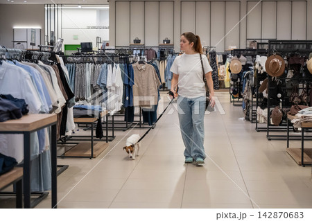 Caucasian woman in a shopping mall with a Jack Russell Terrier dog. Caucasian woman in a shopping mall with a Jack Russell Terrier dog. 142870683