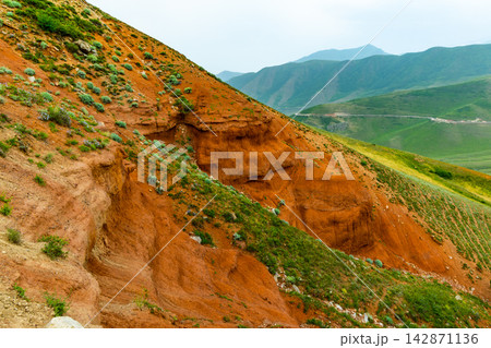 Eroded Red Clay Hillside with Green Vegetation in Kyrgyzstan Eroded Red Clay Hillside with Green Vegetation in Kyrgyzstan 142871136