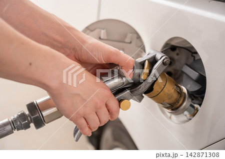 A woman fills a car with gas. Close-up of her hands.  142871308