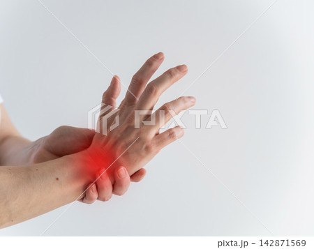 A woman suffers from wrist pain. The source of the pain is depicted as a red spot. 142871569