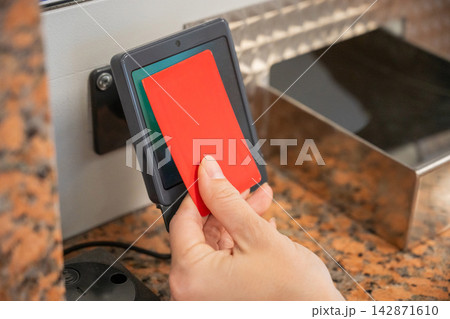 A woman pays for a ride with a bank card at a metro ticket office. 142871610