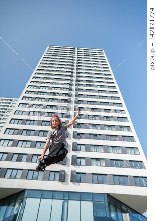 A girl jumps on an outdoor trampoline. A girl jumps on an outdoor trampoline. 142871774