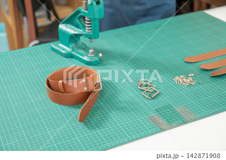 Leatherworker's workbench. Making leather belts. 142871908