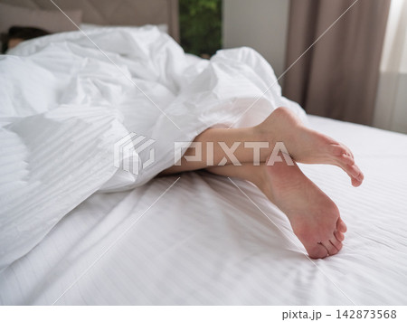 Foot fetish. Bare female feet protruding from under the blanket. Foot fetish. Bare female feet protruding from under the blanket. 142873568