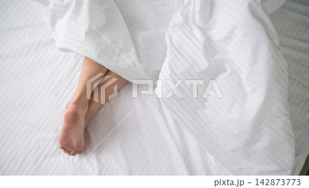 Foot fetish. Bare female feet protruding from under the blanket. Foot fetish. Bare female feet protruding from under the blanket. 142873773
